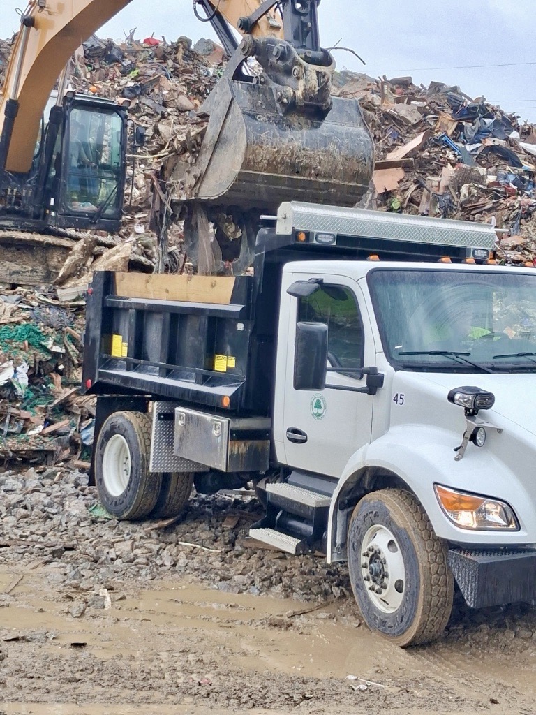 the photo shows a City of Charleston truck helping with removal of debris from the devastating floods that impacted Lewis and Upshur Counties